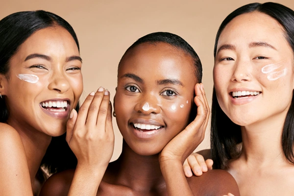 Trzy roześmiane kobiety testują działanie kremu z peptydami o uniwersalnym działaniu pielęgnacyjnym